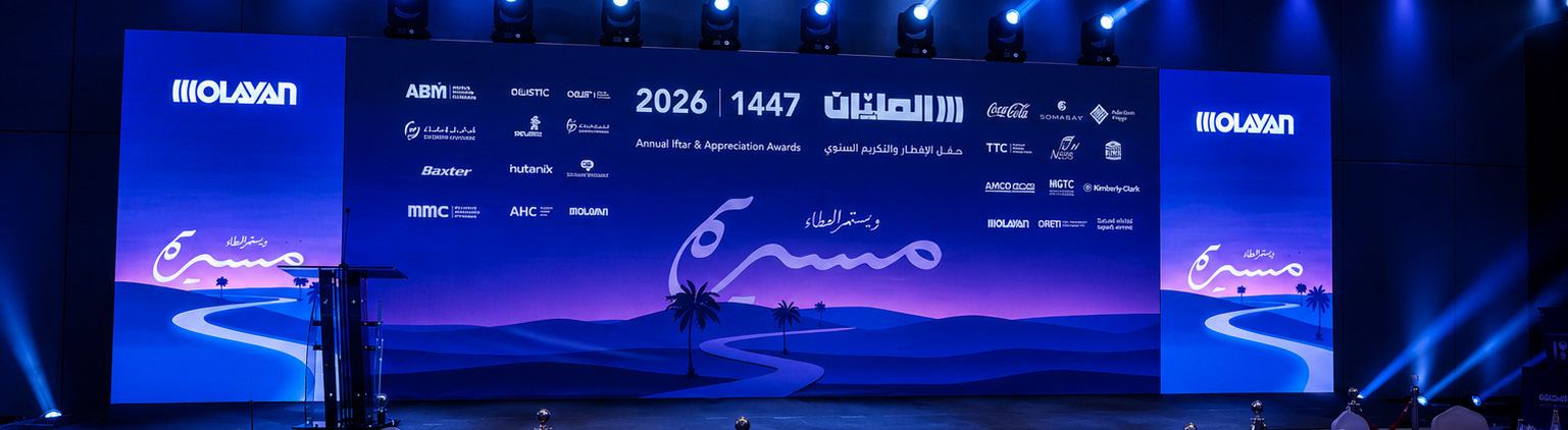 The awards stage: a panoramic dusk landscape with the Masira calligraphy winding across it as a road